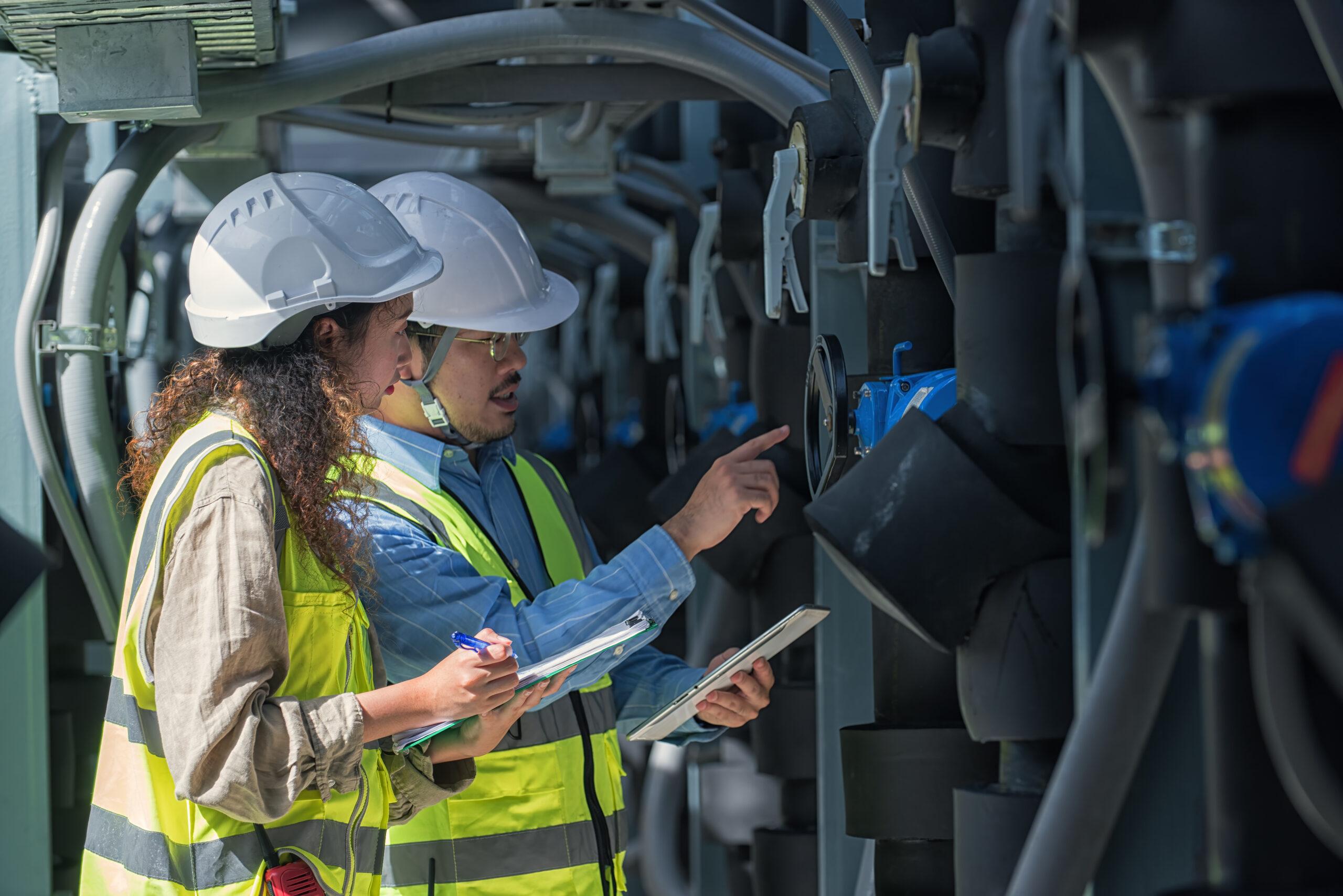Techniker kontrollieren Einstellungen an technischer Anlage | Heizcontainer